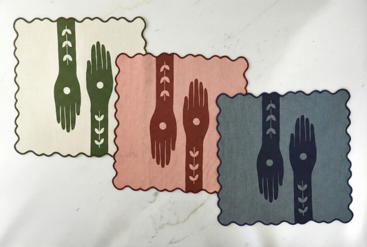 Set of three napkins with hand designs on a marble surface